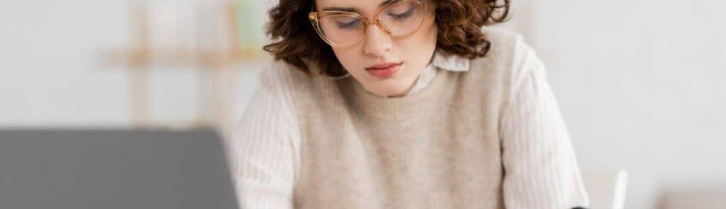 Femme qui travaille avec son ordinateur et son téléphone