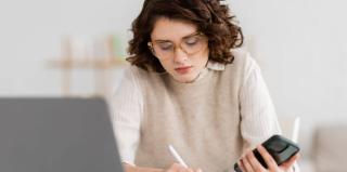 Femme qui travaille avec son ordinateur et son téléphone