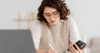 Femme qui travaille avec son ordinateur et son téléphone