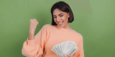 Femme heureuse qui tient une liasse de billets