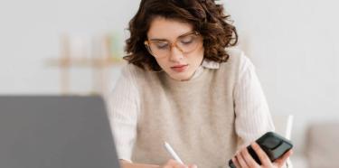 Femme qui travaille avec son ordinateur et son téléphone